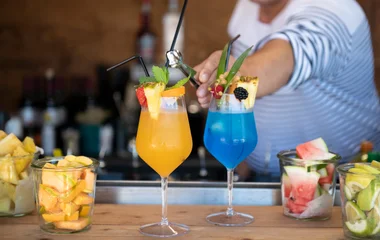 A man and a woman walking on a beach with palm trees