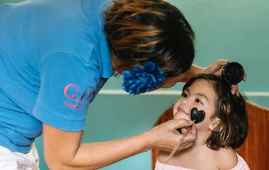 G.O pintando la cara de una niña.