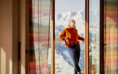 Mulher no quarto com vista para montanha