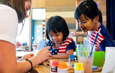 Dos niñas en una actividad de pintura del club infantil.