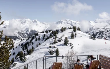 Casal na varanda da suíte, observando os Alpes.
