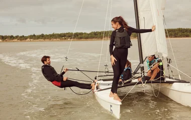 Pessoas encima de um barco a vela.