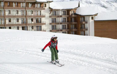 Criança esquiando em um cenário de neve.