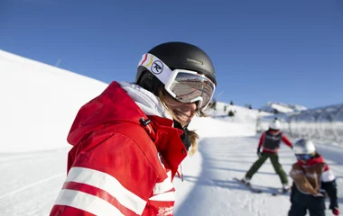 Pessoa sorrindo para câmera em roupas de esqui.