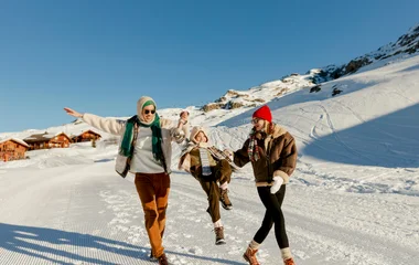 Famille s'amusant sur les pistes à l'Alpe d'Huez dans les Alpes françaises