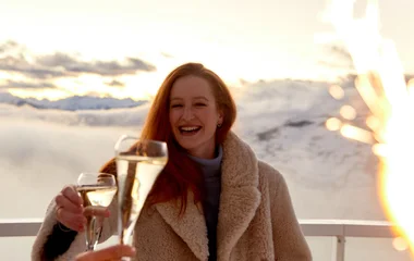 Amigos brindam com espumante para a vista dos Alpes