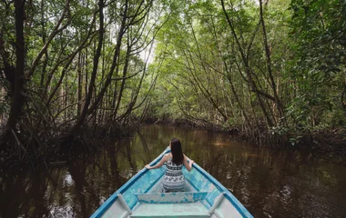 Mulher em passeio de barco pelo rio.