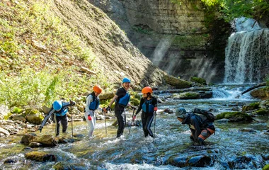 Grupo de excursão nas águas de uma cachoeira de Kiroro Grand