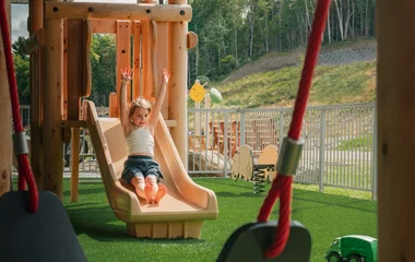 Una niña se desliza por el tobogán.