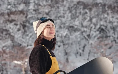 Femme à la montagne avec son snowboard