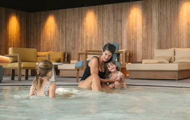 Mujer y dos niñas en la piscina.