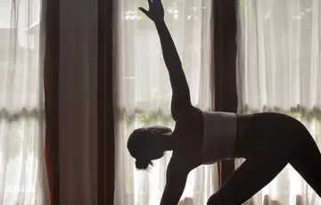 Mulher praticando yoga no resort.