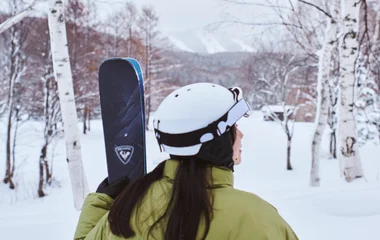 joven sosteniendo esquíes