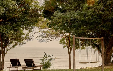 Área ao ar livre com balanço e espreguiçadeiras.