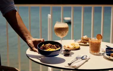 G.O coloca un plato de comida en la mesa, en la que ya hay bebidas.