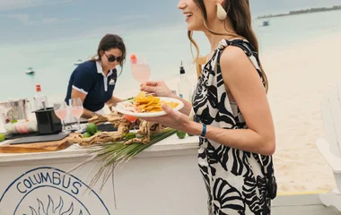 Mujer sosteniendo un plato de bocadillos en el resort.