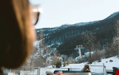 Mulher olhando a vista das montanhas na janela