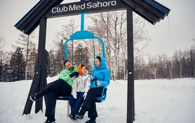Família em balanço com placa do Club Med Sahoro