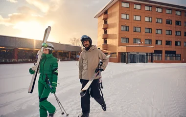 Pareja sosteniendo equipo de esquí.