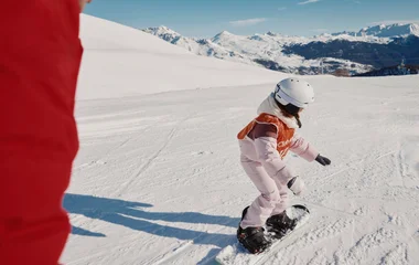 Criança no Club Med praticando snowboard