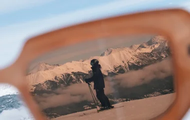 Skieur vu sur le verre d'une paire de lunettes à Serre Chevalier