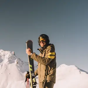 montaña con un hombre parado con su equipo de ski