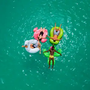 Grupo de amigos deitados em bóias na piscina.