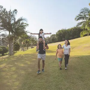 família em campo verde sorrindo enquanto caminha
