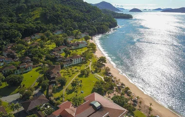 Vista aérea da praia de Rio das Pedras, com as montanhas do lado esquerdo e o mar do lado direito