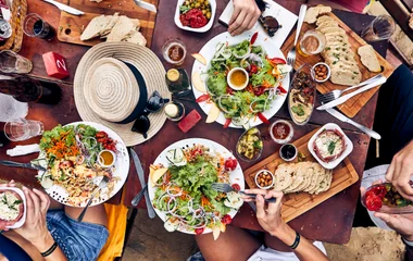 Mesa de restaurante com saladas e pães.