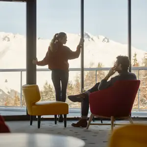 Casal olhando pela janela do resort.