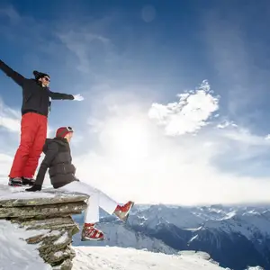 Duas pessoas no pico de uma montanha na neve.