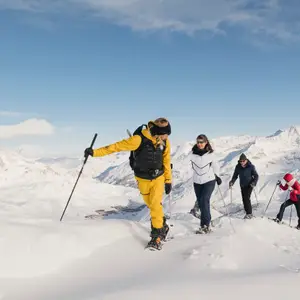 grupo de pessoas caminhando pela neve