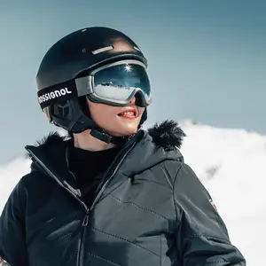 Criança com capacete de esqui na neve