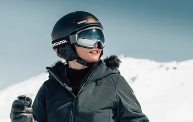 Criança com capacete de esqui na neve