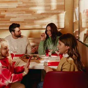 Família com mãe, pai e duas crinaças comendo juntos e conversando