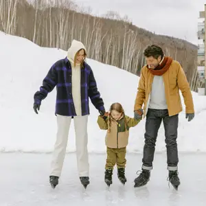 Pais segurando as mãos da filha enquanto patinam no gelo