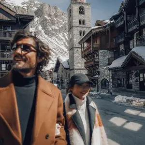 Adultos passeando nas ruas com montanhas nevadas ao fundo