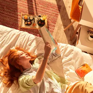 Mulher deitada na cama do quarto do resort