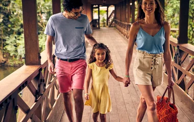 famílai feliz andando sob ponte