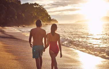 casal de mãos dadas a beira mar