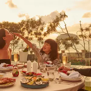 Pai, mão e filha aproveitando um brunch a luz de velas no por do sol.