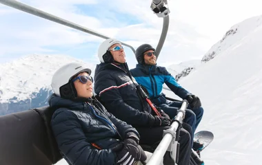 três pessoas em estação de ski