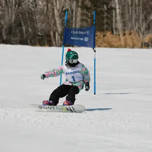 Criança praticando snowboard em resort do Club Med.Criança praticando snowboard em resort do Club Med.
