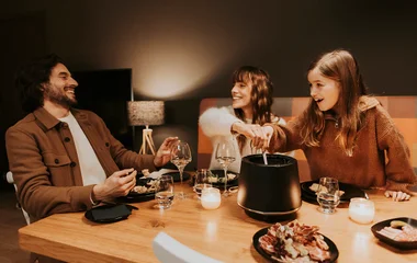 Padre, madre e hija en una cena con fondue.