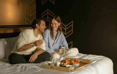 Casal tomando café da manhã na cama.
