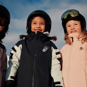 Crianças com trajes de ski na neve.