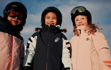 crianças com roupas de inverno em montanha com neve