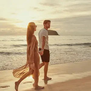 casal de mãos dadas em frente a praia