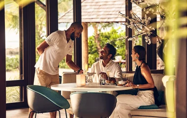 Casal sendo atendido no restaurante do resort.